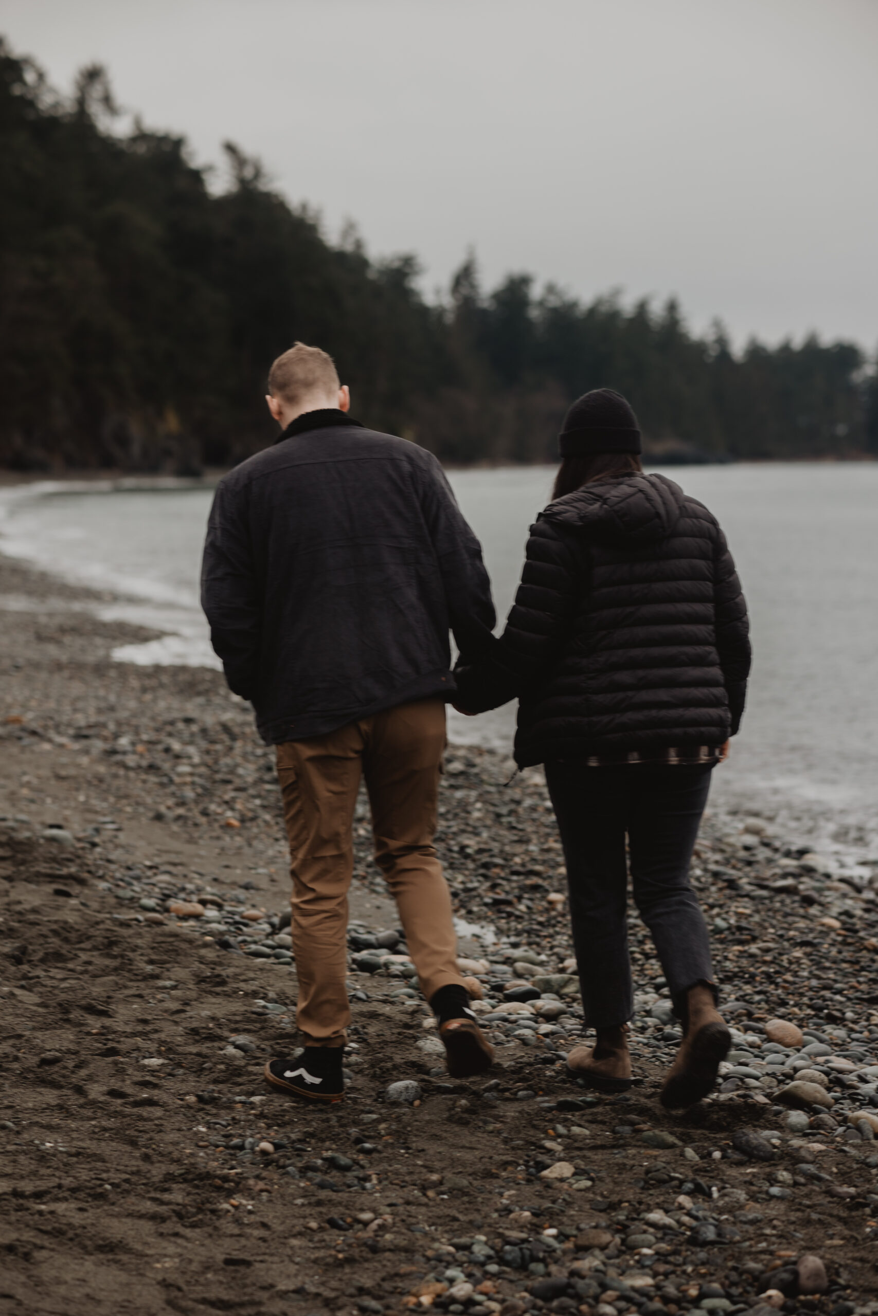 a couple posing together on the beach for their engagement session at Deception Pass State Park