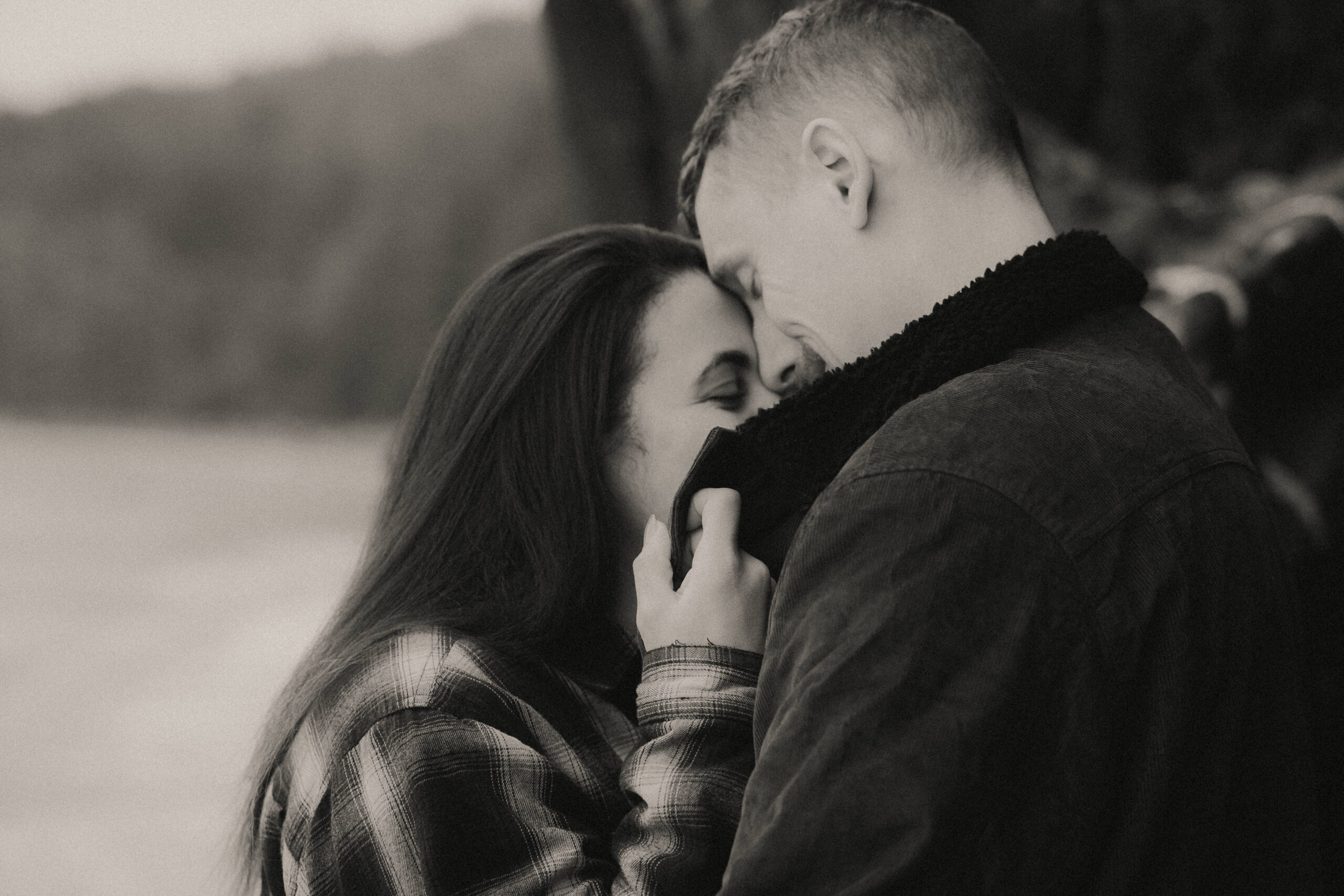 a couple posing together on the beach for their engagement session at Deception Pass State Park