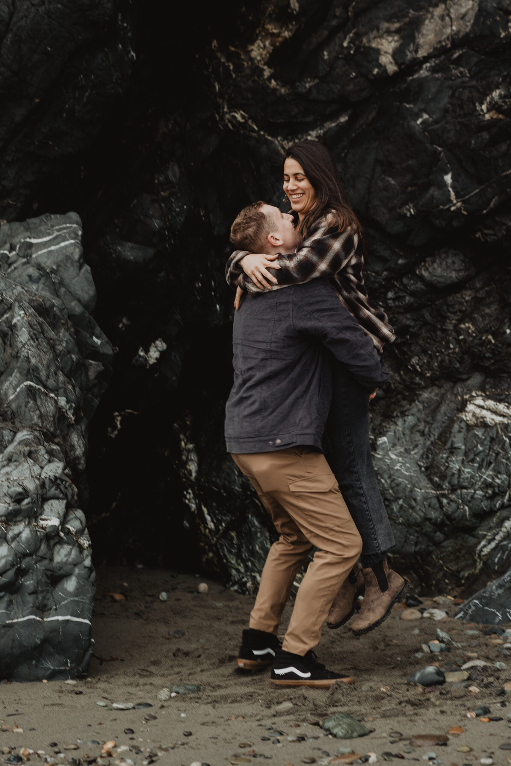 a couple posing together on the beach for their engagement session at Deception Pass State Park