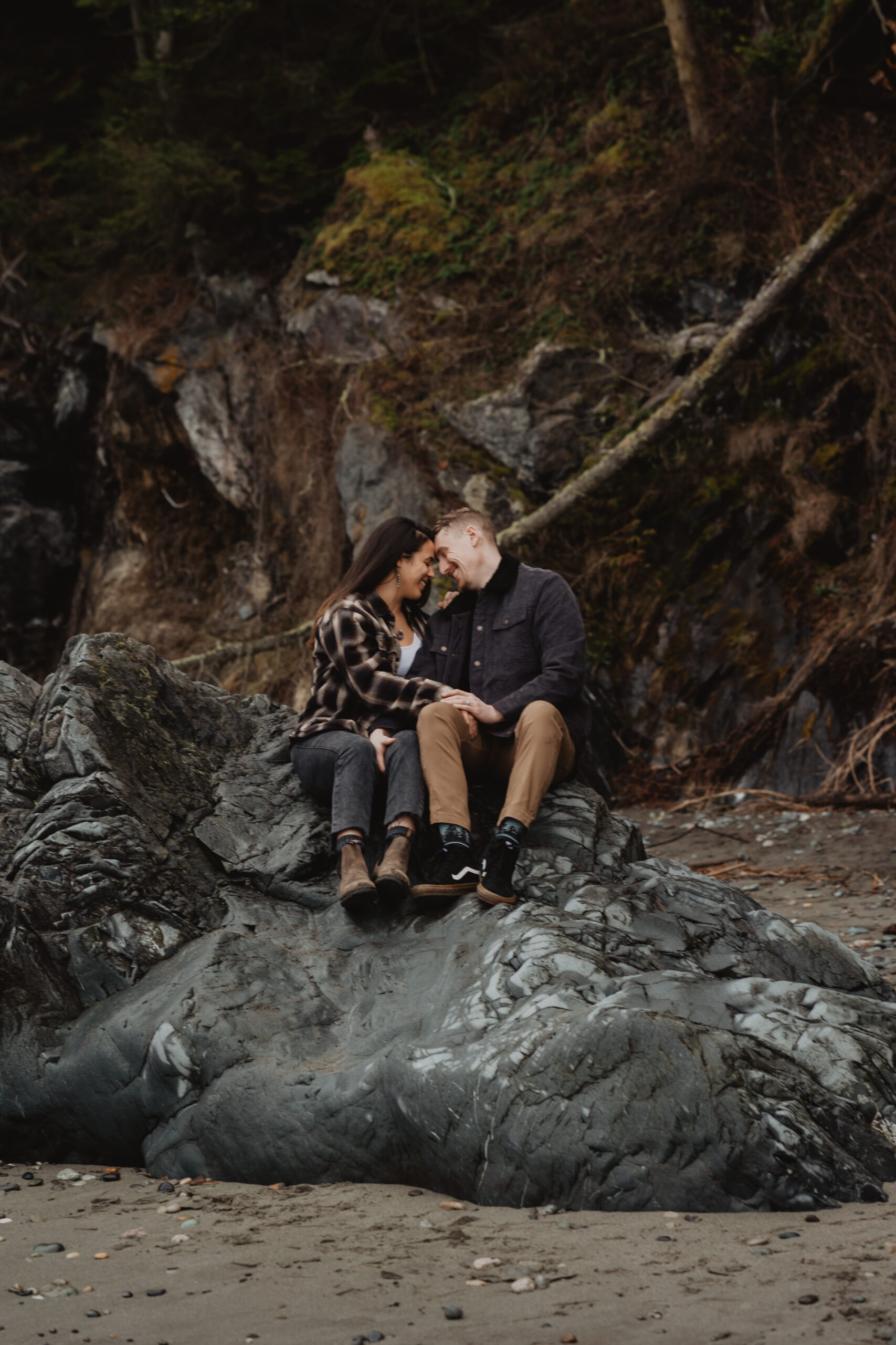 a couple posing together on the beach for their engagement session at Deception Pass State Park