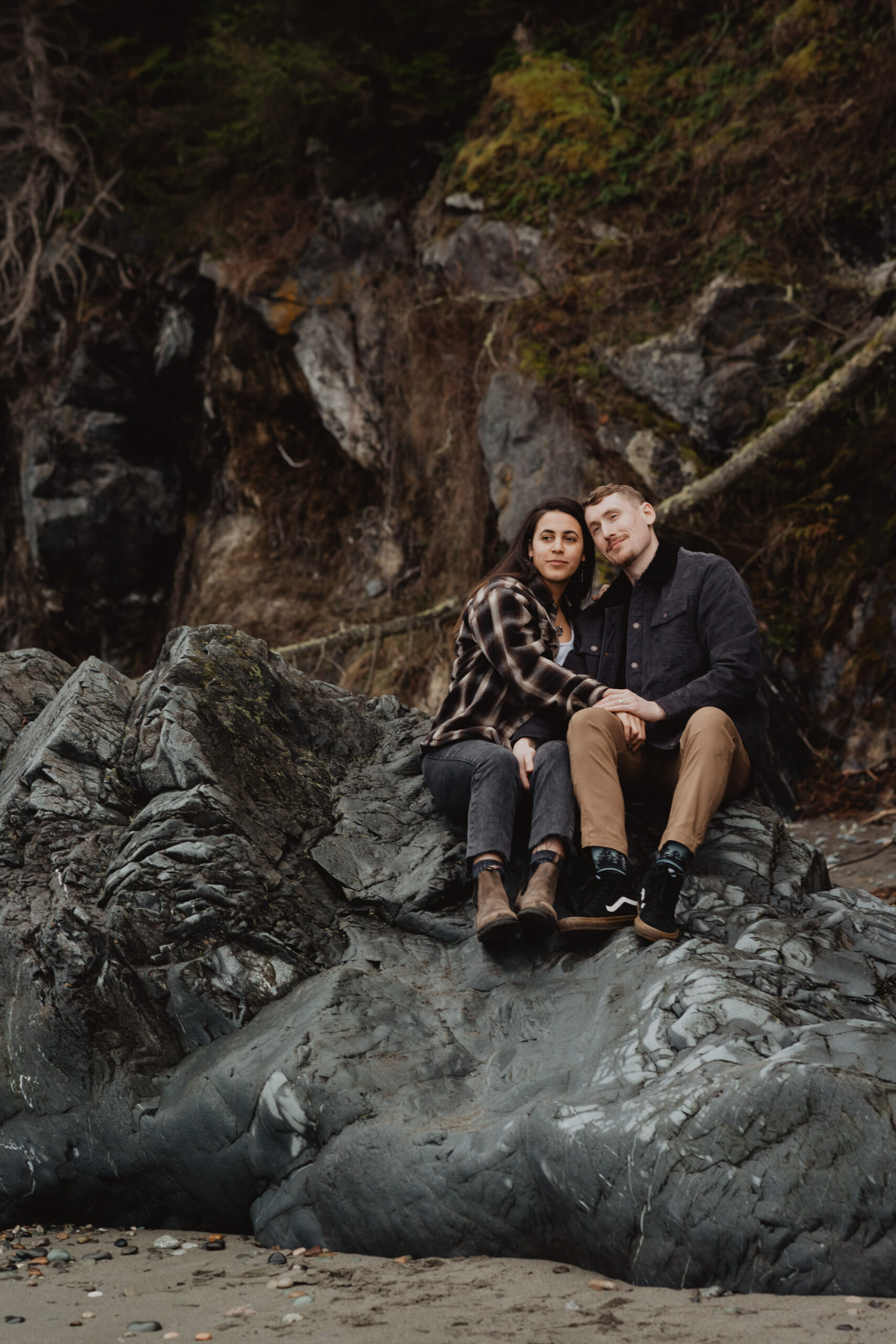 a couple posing together on the beach for their engagement session at Deception Pass State Park
